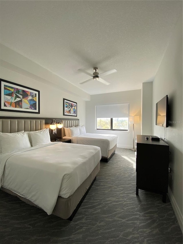 carpeted bedroom featuring ceiling fan and a textured ceiling