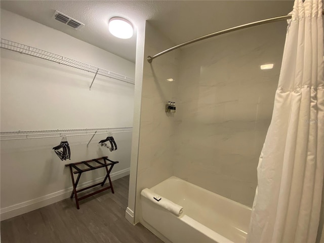 bathroom featuring shower / bath combo, a textured ceiling, and wood-type flooring