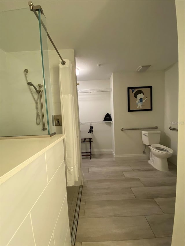 bathroom featuring toilet and wood-type flooring