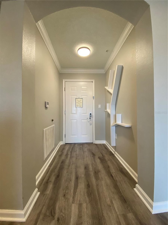 doorway featuring ornamental molding and dark hardwood / wood-style floors