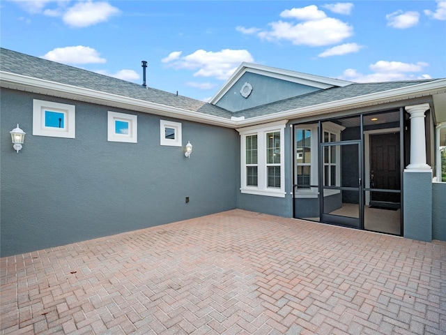 rear view of house featuring a sunroom