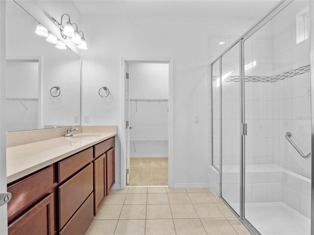 bathroom featuring tile patterned flooring, vanity, and a shower with door