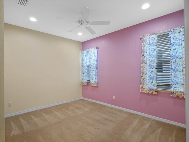 carpeted spare room featuring ceiling fan