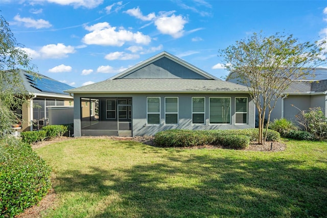 back of property featuring a sunroom and a yard