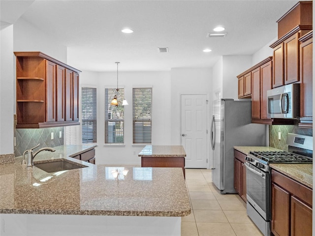 kitchen featuring sink, hanging light fixtures, light stone counters, kitchen peninsula, and stainless steel appliances