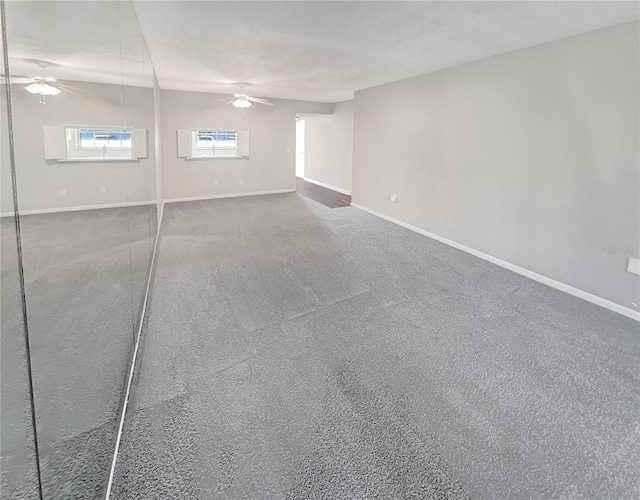 empty room featuring ceiling fan and dark carpet