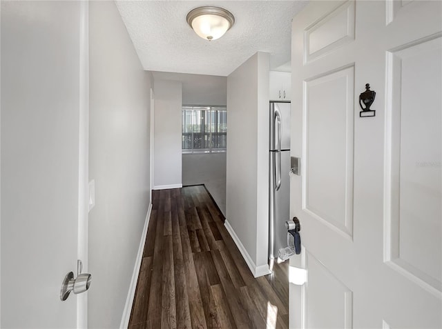 hall with a textured ceiling and dark hardwood / wood-style flooring