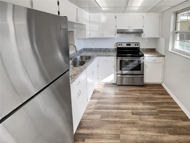 kitchen featuring sink, white cabinets, backsplash, stainless steel appliances, and hardwood / wood-style flooring