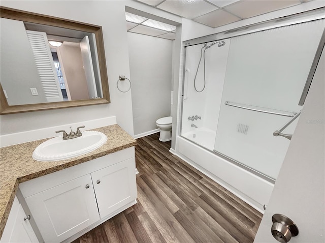 full bathroom featuring toilet, shower / bath combination with glass door, large vanity, and hardwood / wood-style flooring