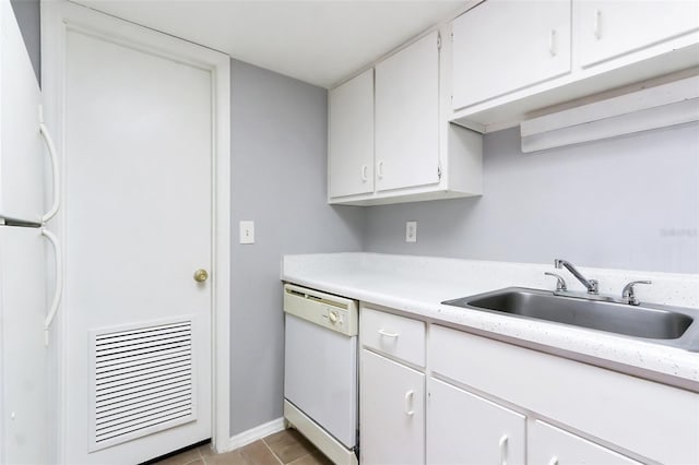 kitchen featuring light tile patterned floors, white appliances, white cabinetry, and sink