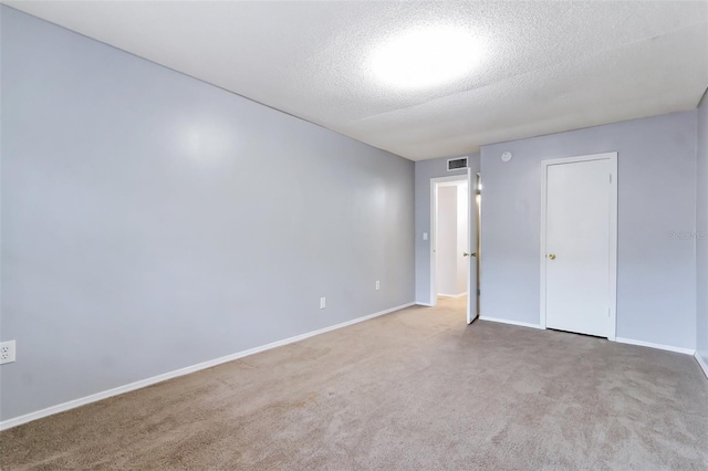 carpeted empty room with a textured ceiling