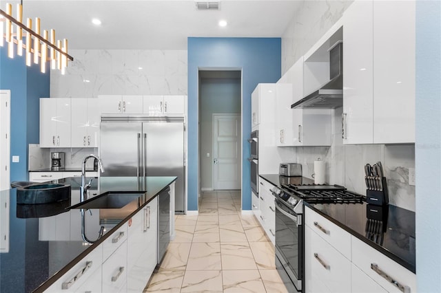 kitchen featuring white cabinets, gas range, backsplash, and wall chimney range hood