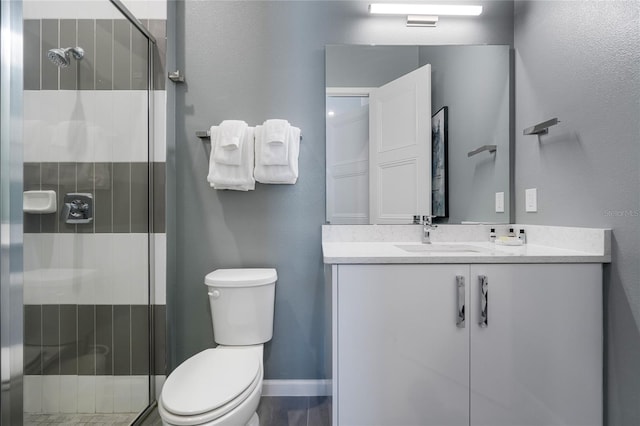 bathroom with vanity, a shower with shower door, and toilet