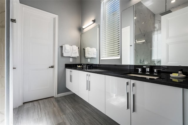 bathroom featuring a shower, vanity, and a healthy amount of sunlight