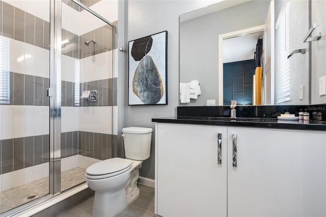 bathroom with tile patterned floors, vanity, toilet, and a shower with shower door