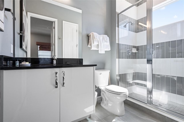 bathroom with tile patterned flooring, vanity, toilet, and a shower with shower door