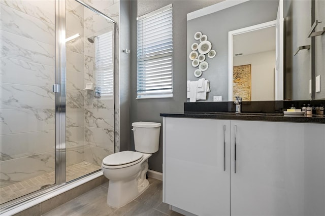 bathroom with tile patterned flooring, vanity, toilet, and an enclosed shower