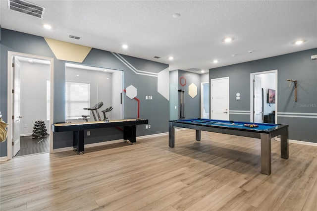 game room featuring a textured ceiling, light wood-type flooring, and billiards