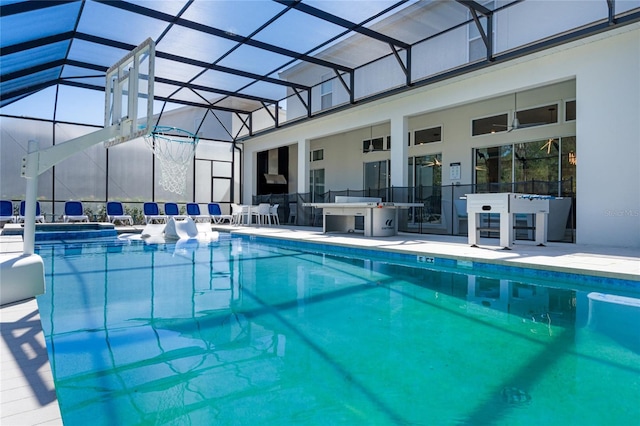 view of pool with glass enclosure and a patio area