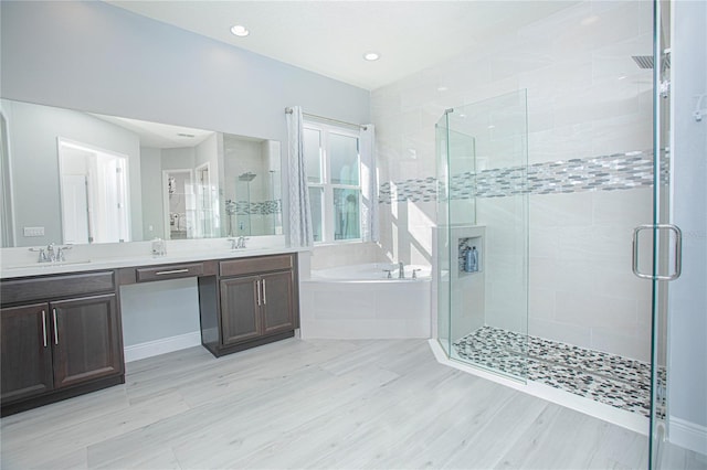 bathroom with double sink, shower with separate bathtub, and large vanity