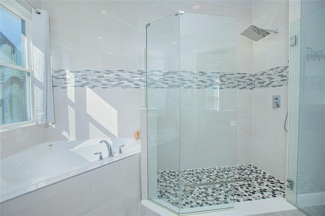 bathroom with tile walls and independent shower and bath