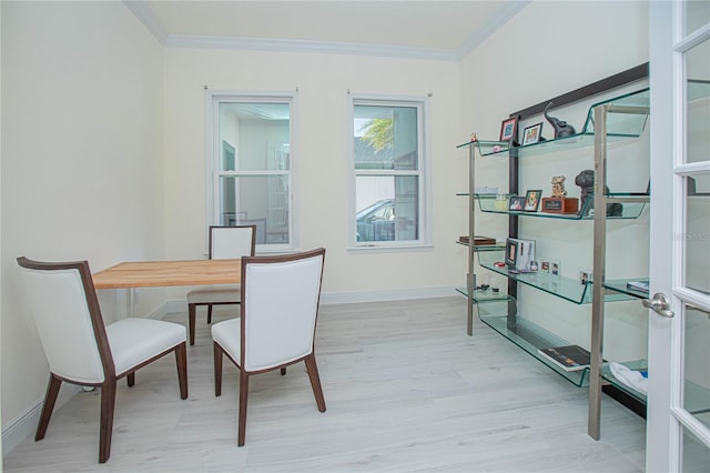 dining room with ornamental molding and light wood-type flooring