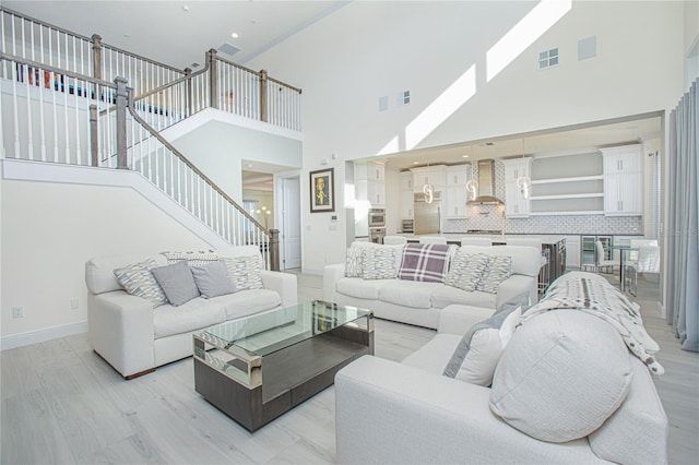 living room with high vaulted ceiling and light hardwood / wood-style floors