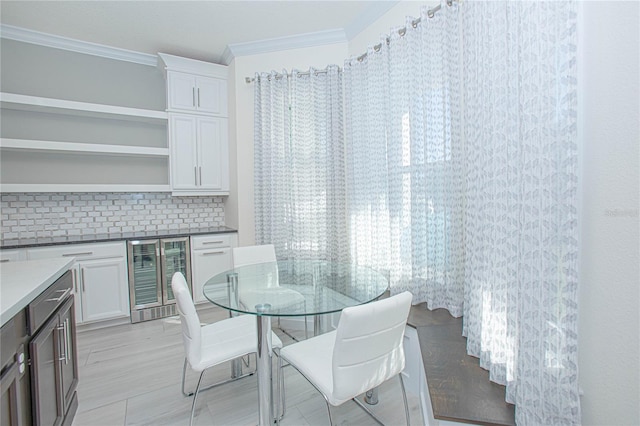 dining area featuring wine cooler and ornamental molding