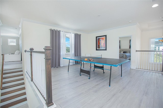 game room featuring ornamental molding and light hardwood / wood-style flooring