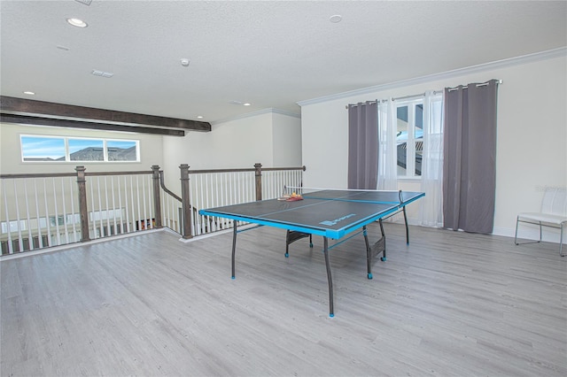 playroom with a textured ceiling, ornamental molding, and light hardwood / wood-style flooring