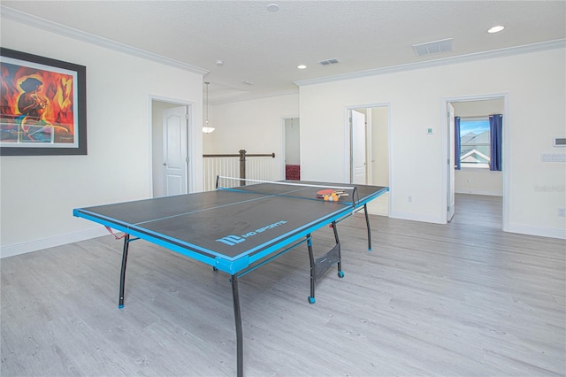 game room with a textured ceiling, light hardwood / wood-style floors, and ornamental molding