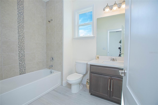 full bathroom featuring tiled shower / bath combo, toilet, and vanity