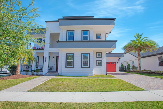 modern home with a porch, a front lawn, and a garage