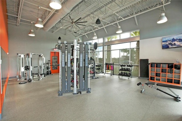 gym with a high ceiling and ceiling fan