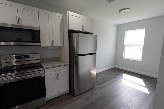 kitchen with appliances with stainless steel finishes, light wood-type flooring, and white cabinetry