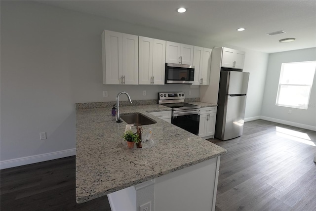 kitchen featuring white cabinetry, sink, light stone countertops, kitchen peninsula, and appliances with stainless steel finishes