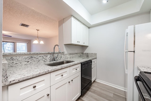 kitchen with light stone countertops, an inviting chandelier, light hardwood / wood-style floors, sink, and black dishwasher