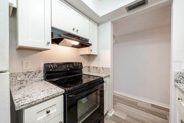 kitchen with light stone counters, white cabinets, electric range, and light hardwood / wood-style flooring