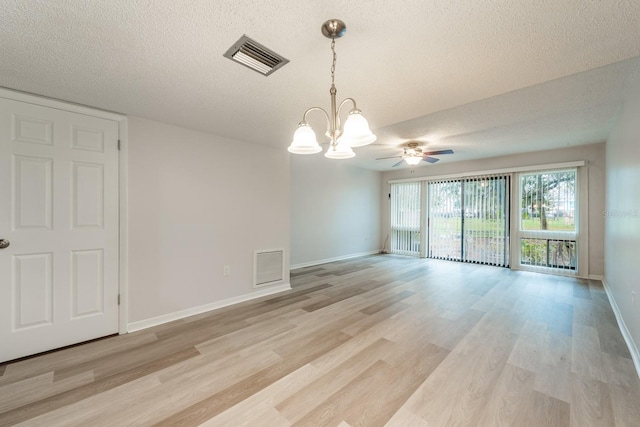 unfurnished room with a textured ceiling, ceiling fan with notable chandelier, and light hardwood / wood-style flooring