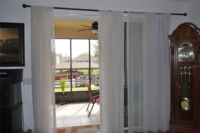 doorway to outside with tile patterned floors and ceiling fan