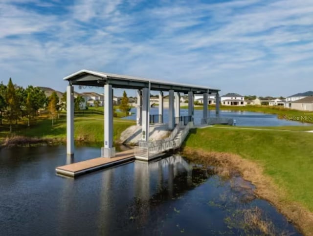 dock area featuring a water view and a lawn