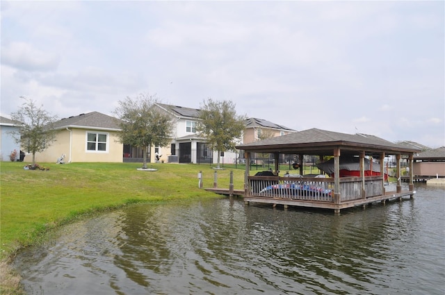 view of dock with a water view, a gazebo, and a lawn