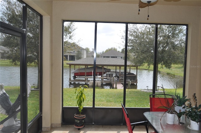 sunroom with a water view and ceiling fan