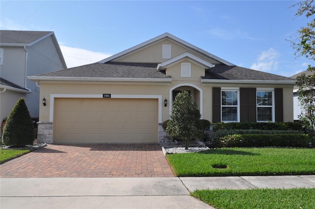 view of front of house featuring a garage and a front lawn