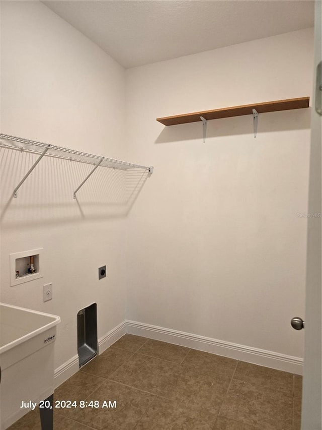 washroom with sink, electric dryer hookup, hookup for a washing machine, and dark tile patterned floors