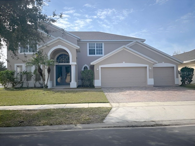 view of front of home featuring a front yard, french doors, and a garage