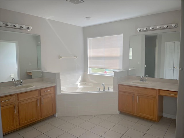 bathroom featuring tile patterned floors, tiled bath, and vanity