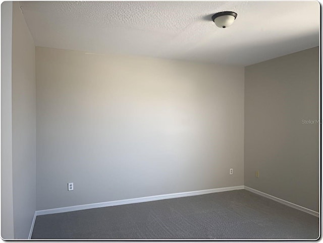 carpeted empty room with a textured ceiling