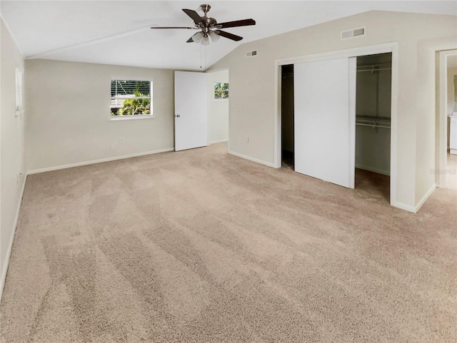 unfurnished bedroom featuring light colored carpet, ceiling fan, and lofted ceiling