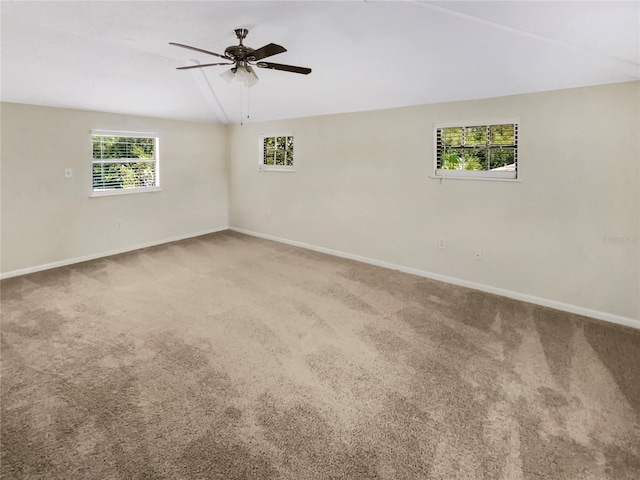 unfurnished room with carpet flooring, ceiling fan, and a wealth of natural light